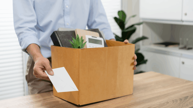 Dipendente che rassegna le dimissioni con lettera e una scatola piena di effetti personali.