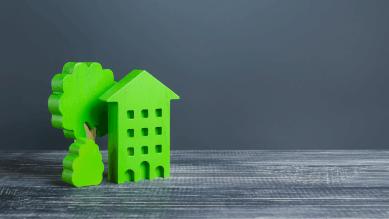 Edificio aziendale con alberi verdi su sfondo grigio che richiamano il fenomeno del greenwashing sul tema green claims.